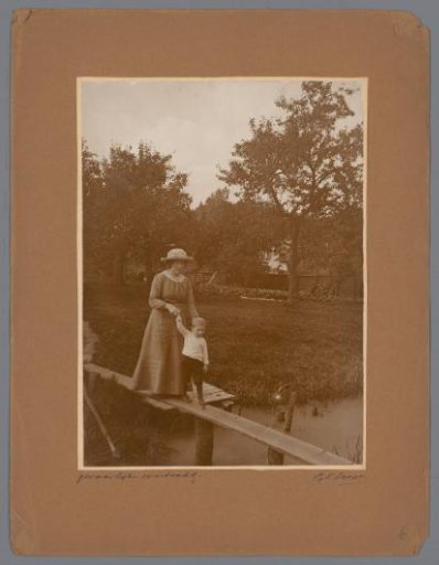 Portrait of a woman with a boy, walking across a plank over a ditch