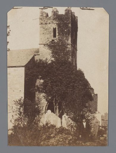 View of a Medieval Church Tower with Battlements and Part of the Church with a Cemetery