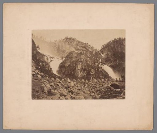 Rocky mountain landscape with waterfall and bridge