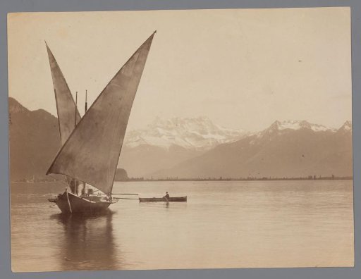 Sailing ship and rowboat on a lake, glaciers in the background