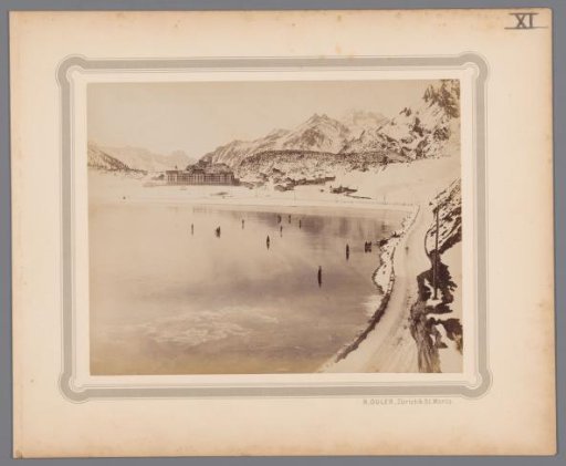 Snow-covered mountain landscape with a half-frozen lake and mountains [Alps] in the background