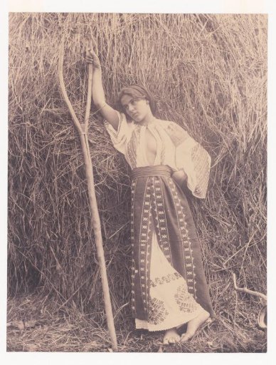 Woman with a Pitchfork and Open Shirt, Leaning Against a Haystack