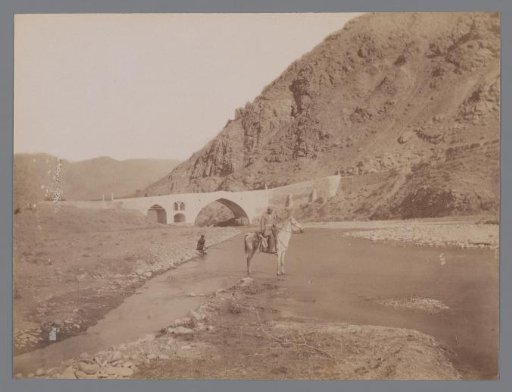 Landscape with a bridge and a river with a rider on horseback and hills on both sides ("La route de Rescht, Pont Kerezje [?]"), Iran