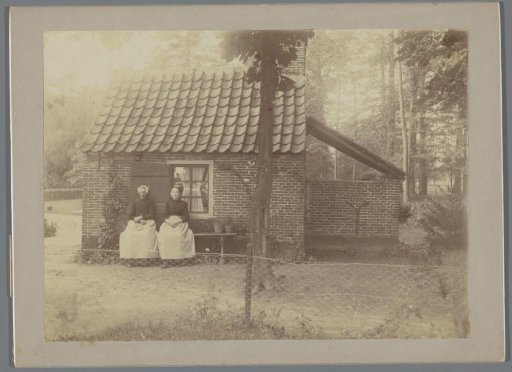 Portrait of two unknown women by a garden house
