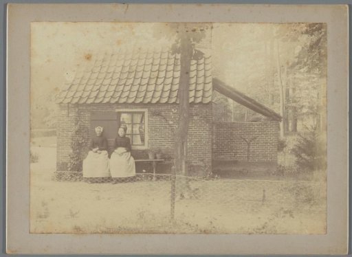 Portrait of two unknown women by a garden house