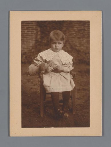 Portrait of a Child on a Chair with a Doll