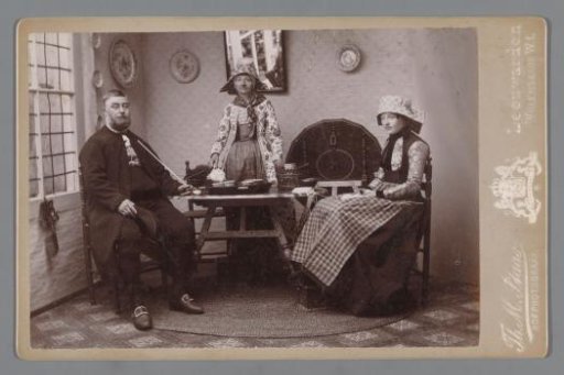 Portrait of an unknown man and two unknown women in traditional dress from Hindeloopen