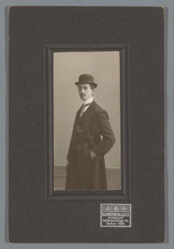 Portrait of G.N.P. van Eijk, standing with a hat