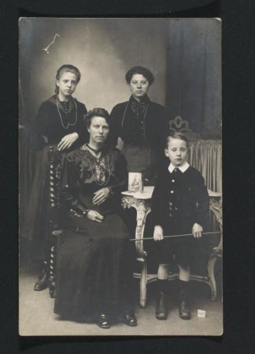 Portrait of Two Women, a Boy, and (on the left, probably) G.A. Brusse-Urtebise Around a Photograph of a Man