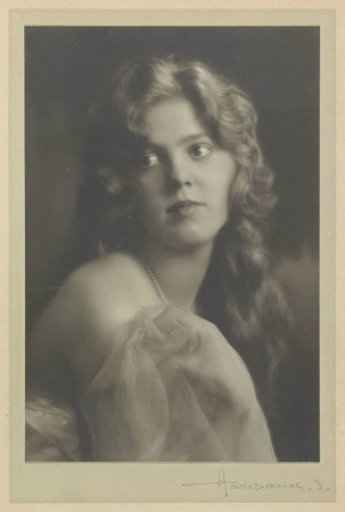 Portrait of G.A. Urtebise with loose long hair, pearl necklace and fabric draped around bare shoulders