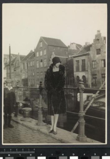 Portrait of G.A. Urtebise in a fur coat with a bowler hat standing by the railing of a canal