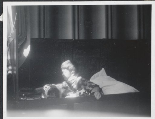 Herbert Hondius in a child's kimono in bed