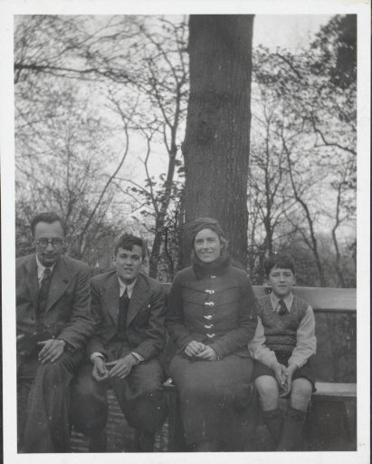 Mrs. A.H. Crone, a man, and two sons on a bench in Valkenburg