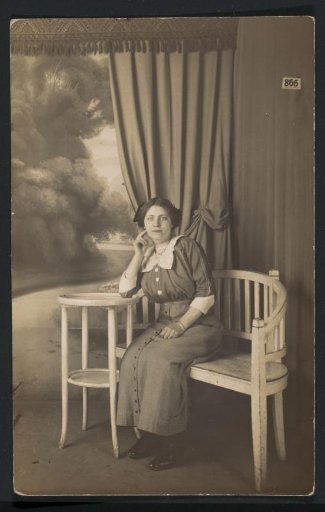 Portrait of a woman in a skirt with buttons and a blouse, seated