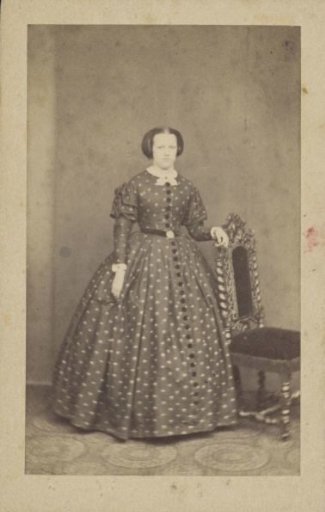 Portrait of a woman in a long spotted dress with a sash