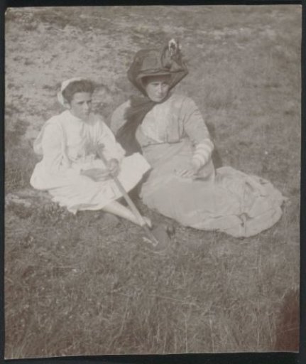 Mrs. M. Lobry van Troostenburg de Bruyn-Simon Thomas and her daughter sitting in the dunes