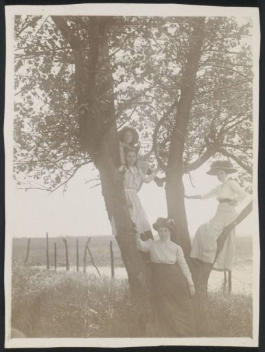 Mrs. M. Lobry van Troostenburg de Bruyn-Simon Thomas posing by a tree together with girls including a daughter