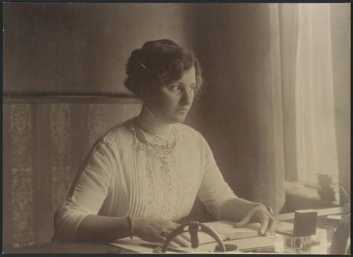 Portrait of a woman in a blouse sitting at a desk