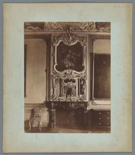 Interior with a fireplace, a mirror, and paintings