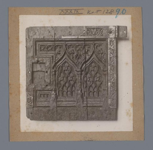 Wooden panel decorated with shapes of church windows, possibly a cabinet door
