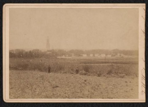 Figures in a landscape with a village or town in the background