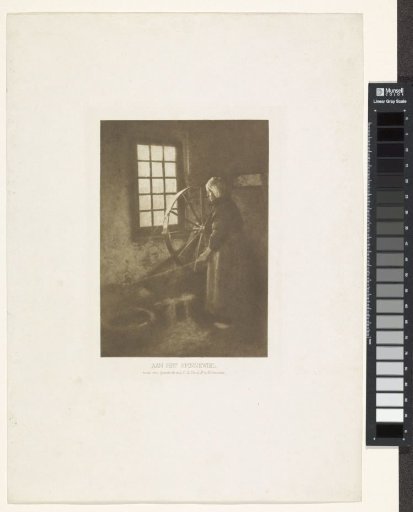 Woman at a spinning wheel in a dark room