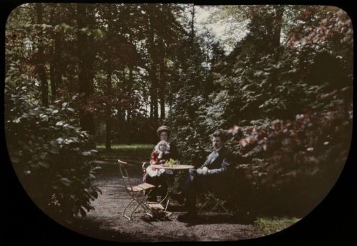 Tine and Jacob Olie sitting at a table in the garden of house Schoonoord, De Bilt