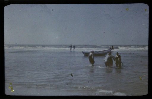 Bathers and a skiff in the surf, North Sea beach