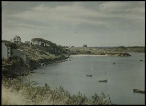 View of a coastal landscape, with several rowboats in the water