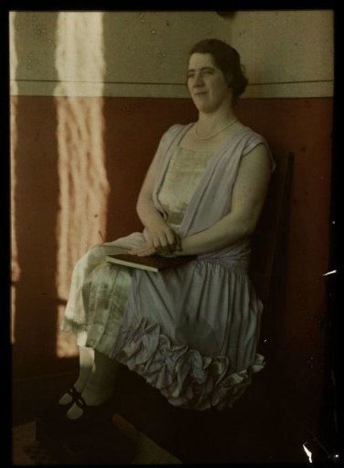 Portrait of Tine sitting in a chair, with a book on her lap