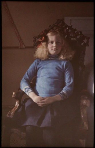 Portrait of Fifi seated on a wooden chair