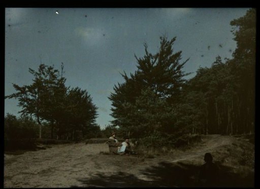 Tine and an unknown woman seated in a sand dune