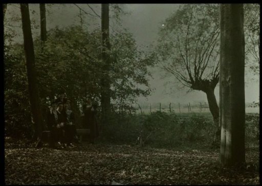 Tine, Fifi, and Aagje (standing), and two unknowns under trees on the shore of a river