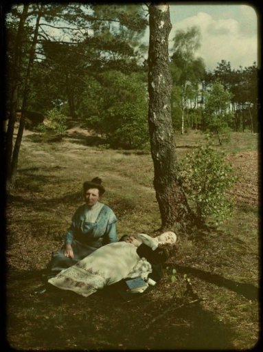 Tine (lying) and Aagje (seated) by a tree at the edge of a heath field or field