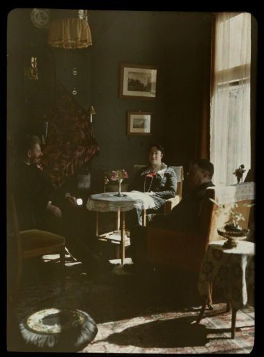 Jacob Olie jr. and a man and woman seated around a table in an interior