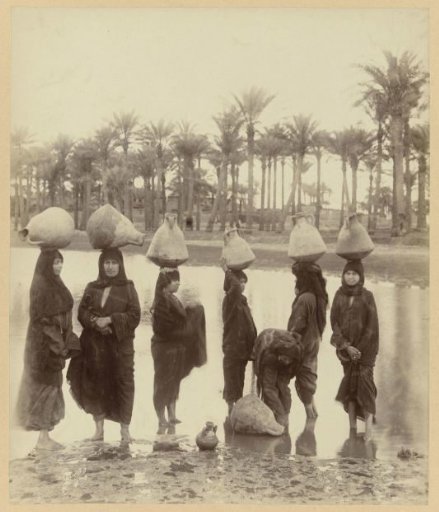 Group of women with jugs on their heads by the Nile