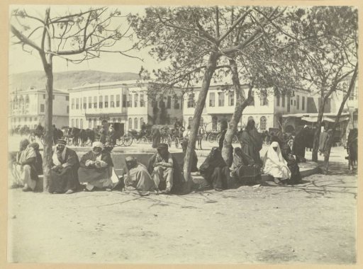 People sitting around a fountain on a square in Damascus