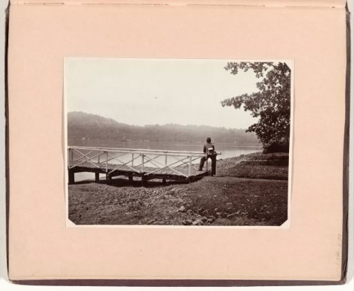 Man at a bridge looking out over water