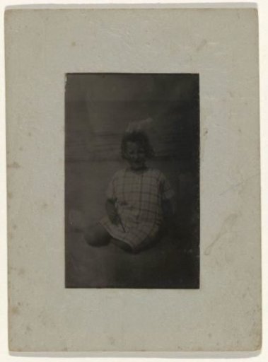 Portrait of Koosje Ochse in a checkered dress sitting on the beach