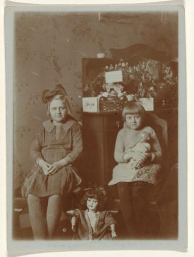 Portrait of two unknown sitting girls in an interior