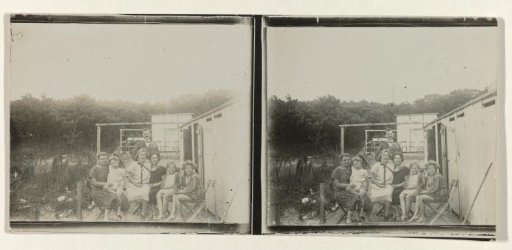 Group of people next to a row of changing rooms on the beach at Valkeveen