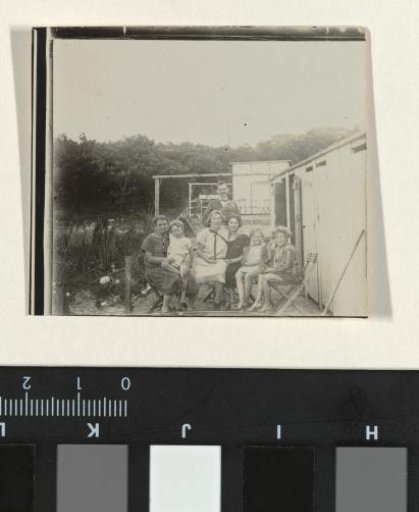 Group of people next to a row of changing rooms on the beach at De Wijde Blik