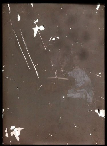 Standing and seated figure (barely visible), including a girl dressed in a blue dress
