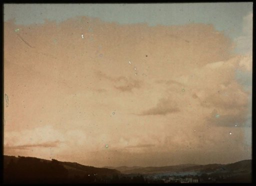 Sunset over a valley, with a small town with white houses in the foreground
