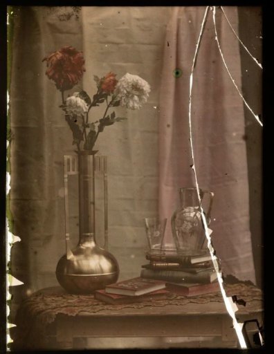 Still life with flowers in a vase, books, a carafe and a glass