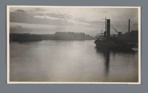 A steamship, seen from the side, in a harbor