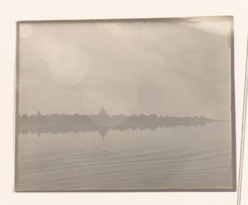 View of several temples on the vegetated bank of a river, South-East Asia