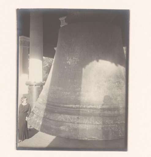 A white lady posing at a bell, part of a Buddhist shrine, Myanmar
