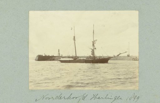 Breakwater with a wooden pier and two-masted ship