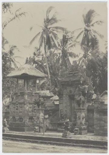 A decorated gate with a small temple in front